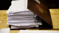 Eduskunnan puolustusvaliokunnan jäsenen asiakirjakansio valiokunnan sotilastiedustelulakia koskevan mietinnön tiedotustilaisuudessa eduskunnassa Helsingissä