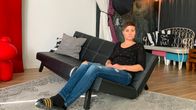 Heidi Noponen istuu risalla sohvalla