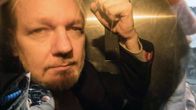 Julian Assange näyttää nyrkkiä kameroille.