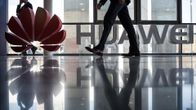 Mies kävelee Huawei logon ohi