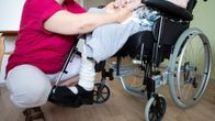 Lähihoitaja pitelee potilaan käsistä