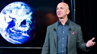 Jeff Bezos pitää puhettaan. Taustalla on maapallo kuvattuna avaruudesta.