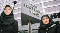 Kuvassa on kaksi hijabia käyttävää poliisia Lontoossa Scotland Yardin tilojen edessä.