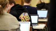 Yo-kokelaita ja kannettavia tietokoneita juuri ennen ylioppilaskirjoituksien äidinkielen lukutaidon kokeen alkua.