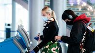 Kasvomaskiin pukeutuneita matkustajia Helsinki-Vantaan lentoasemalla.