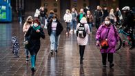 Kasvomaskeihin pukeutuneita ihmisiä Helsingin rautatieaseman edustalla.