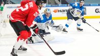 Dylan Cozens Suomen maalin kulmalla kiekon kanssa. Kari Piiroinen on tarkkana maalillaan.