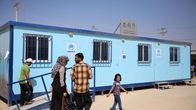 Ihmisiä YK:n pakolaisjärjestö UNHCR:n toimipisteen edessä Zaatarin pakolaisleirillä. 