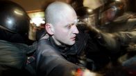 Venäläiset poliisit taluttavat oppositiojohtaja Sergei Udaltsovia Moskovassa.