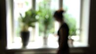 Naisen silhuetti ikkunaa vasten