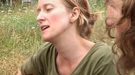 European Rainbow Gathering -tapahtumaan osallistuvia istuu nurmikolla Leppävirralla.