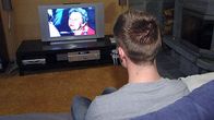 Mies katsoo televisiota