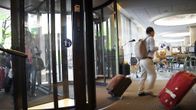 Turistit saapumassa hotellin aulaan Helsingissä.