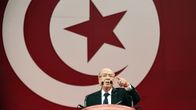 87-vuotias veteraanipoliitikko Beji Caid Essebsi pitää puhettaan Tunisian lippu taustalla.