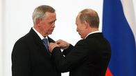 Vladimir Putin asettaa jotain iäkkään miehen, Valentin Rasputi rintaan.