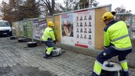 Huoltomiehet nostavat vaalimainonta julistetta pois paikaltaan.