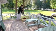 Liisa Lagerstam lakaisee leikkimökin terassia Laukon kartanossa. 
