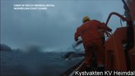 Rannikkovartija veneen kannella ja valaan pyrstö vedessä.