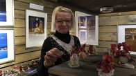 Nainen laittaa joulukoristeita hyllylle.