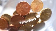 Kolikoita Nordean logolla varustetussa säästöpossussa.