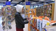 Fereshte Khodadadi selailee kirjoja Porin kirjastossa