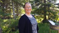 Kuvassa Eva-Maria Strömsholm metsämaisemassa.