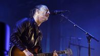Radioheadin laulaja Thom Yorke lavalla kitaran ja mikrofonin kanssa.