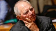 Wolfgang Schäuble nojaa vakavana poskeensa.