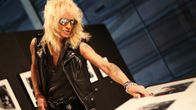 Rock-tähti Michael Monroe katselee Hanoi Rocks -yhtyeen valokuvia.