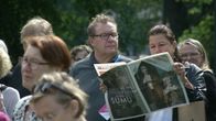 Teatterikesän avajaisissa yleisön joukossa istuva pariskunta lukee Teatterikesän ohjelmalehtistä.