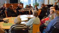Vanhukset kuuntelevat kaupunginorkesterin konserttia.
