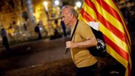 Mies kävelee Katalonian lipun kanssa
