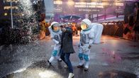 Slushiin matkalla oleva messuvieras ottaa valokuvia lumipyryssä messukeskuksen edustalla.