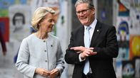 vasemmalla vaaleatukkainen nainen ja oikealla harmaatukkainen mies.