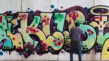 Graffitin maalaaja työssään.
