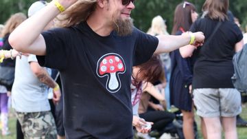 Sienipaitainen mies tanssii Ilosaarirockissa.