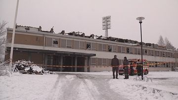 Miehiä palaneen koulun pihalla