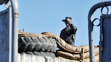 Ukrainalainen sotilas vartioi sotilastukikohdan sisäänkäyntiä Bakhchisarayn kaupungissa Krimin niemimaalla.