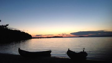 veneitä rannassa iltaruskossa.