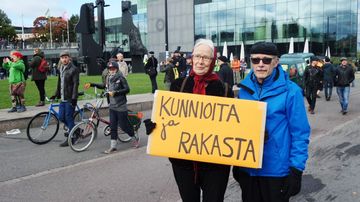 Nainen ja mies kyltin kanssa.