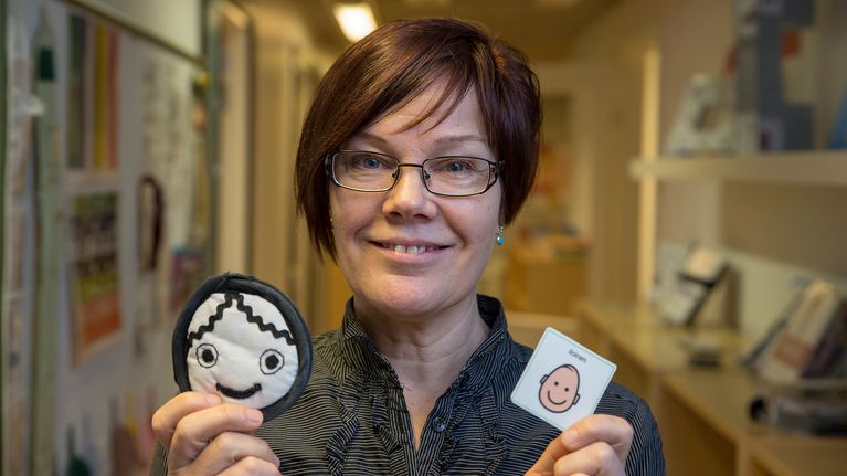 Tikoteekin kehittämispäällikkö Eija Roisko näyttää erilaisten naamojen kuvia.