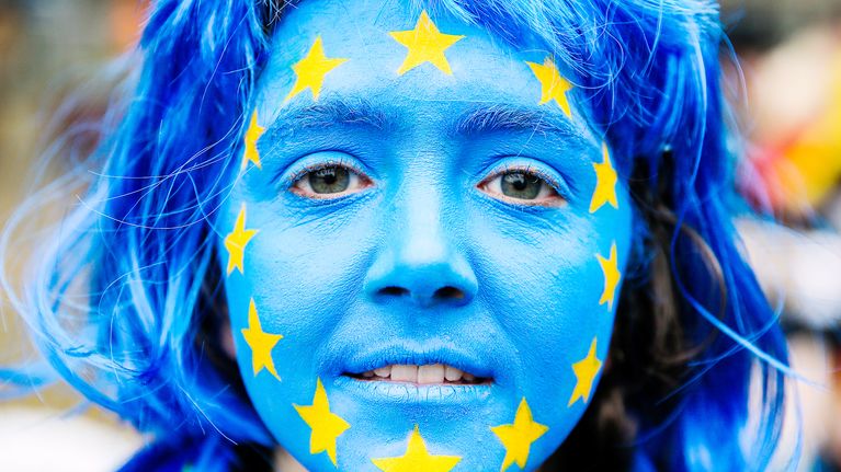 Eu:n lippu maalattuna nuoren naisen kasvoihin.