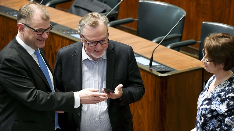 Pääministeri Juha Sipilä ja kansanedustaja  Antero Laukkanen (kd.) tutkivat kännykkää eduskunnan täysistunnossa.