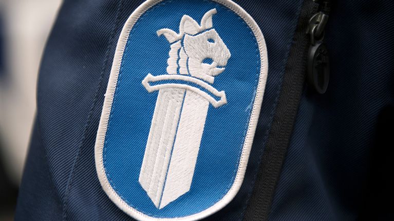 Poliisiin logo poliisi univormussa
