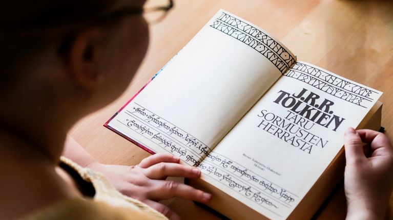 Taru Ringa Kortelainen lukee Taru Sormusten Herrasta -kirjaa.