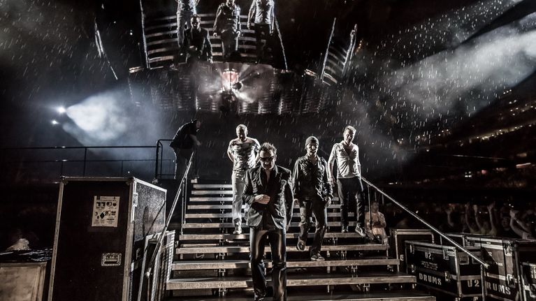 U2-bändi astelee alas 360-kiertueen lavalta rankassa vesisateessa Minneapoliksessa heinäkuussa 2011.