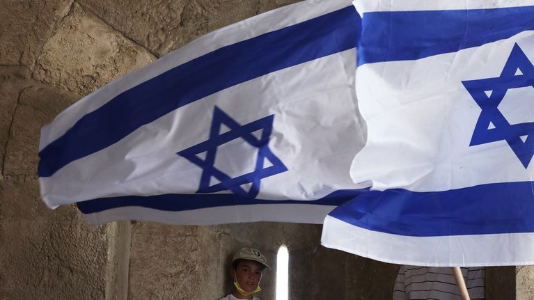 Kuvassa on juutalaisia, joista kaksi heiluttaa Israelin lippua. 