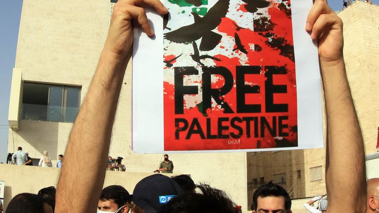 Kuvassa jordanialainen mies pitää käsissään kylttiä, jossa vaaditaan palestiinalaisten vapauttamista. Mies osoitti mieltään Jordanian pääkaupungissa Ammanissa maanantaina. 