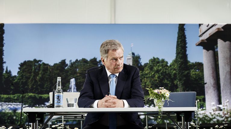 Sauli Niinistö pöydän ääressä.
