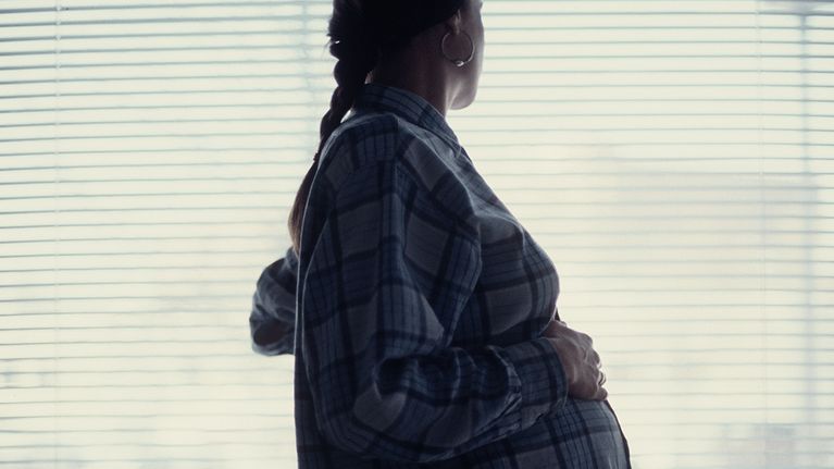 Kuvassa odottavan äidin siluetti ikkunaa vasten.